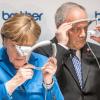 Der Schweizer Bundespräsident Johann Schneider Ammann und Bundeskanzlerin Merkel schauen durch eine Augmented Reality Datenbrille die u.a. bei der Montage von Kühlschränken eingesetzt wird.