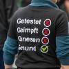 Getestet, Geimpft, Genesen, Gesund steht auf dem Shirt eines Demonstranten der aus Protest gegen die Corona-Politik mit Gleichgesinnten durch Berlin zieht.  