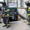 Feuerwehrmänner stehen in New York vor einer U-Bahn Station. Eine U-Bahn ist in der Nähe des Stadtteils Harlem entgleist. 34 Menschen wurden leicht verletzt.