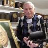 Heinz Maxzin mit dem Funkeninduktor im Wertinger Radiomuseum. Neben ihm ein Bild von Hans Wald, der ihn zum Sammeln von Radios brachte. 	