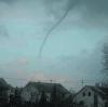 Aus einer Gewitterwolke senkt sich der für Tornados typische Rüssel herab. 