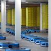 Noch sind die Regale in der umgebauten Lagerhalle von Amazon in Graben leer, doch die blauen Roboter stehen bereit. Sie werden künftig bei der Warenabfertigung helfen und die Regale direkt zu den Mitarbeitern transportieren. Rund 150 Millionen investiert der Onlineversandriese in die neue Technologie.