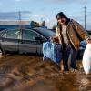 Ein Mann trägt im Januar in Merced, Kalifornien, Habseligkeiten aus seinem überfluteten Haus.