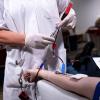 Eine Mitarbeiterin vom Blutspendedienst des Bayerischen Roten Kreuzes entnimmt während einer Blutspende von einer Frau eine Blutprobe für die Laboruntersuchung.