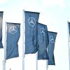 Fahnen mit dem Logo des Autoherstellers Mercedes-Benz wehen im Wind.