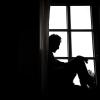 Ein Mann sitzt vor einem Fenster. Nach einer Corona-Infektion erleiden Patienten häufiger neurologische oder psychische Erkrankungen.