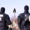Polizisten beobachten zwei Klimaschutzaktivisten am Rande des Braunkohledorfes Lützerath. In dem Dorf soll nun Lebensgefahr herrschen.