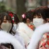 Besonnene Japaner? Ja, aber nicht mehr um jeden Preis. Der Missmut nimmt zu. Zwei Frauen in Yokohama mit Kimono und Gesichtsmaske. 	