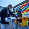 Eine Mitarbeiterin des Impfteams kontrolliert die Ausrüstung: Die  Firma Bäuerle-Ambulanz schickt die Impfteams im Stadtgebiet Augsburg los.
