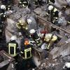 Feuerwehrleute durchsuchen die Trümmer des explodierten Hauses in Germering. 