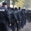 Polizisten rücken am Freitag  an der Zufahrt der Sportanlage Süd in Augsburg, nachdem in der Nacht zu Freitag ein Polizist bei einer Verfolgungsfahrt in Augsburg erschossen wurde, zur Durchsuchung des Waldgebietes aus. 