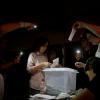 Freiwillige Wahlhelfer zählen in einem Wahllokal in Barcelona die Stimmen beim Referendum in Katalonien mit Hilfe von Handy-Taschenlampen aus.