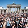 Menschen feiern vor dem Brandenburger Tor in Berlin zu Techno-Musik.