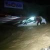 Ein Feuerwehrmann arbeitet im italienisch-französischen Alpenübergang Colle di Tenda an einem Auto, das im Eingang eines Tunnels im Hochwasser feststeckt.