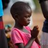 Ein Mädchen aus dem Südsudan betet bei einem Gottesdienst im Flüchtlingslager Bidi Bidi (Uganda). Kinder in Kriegsgebieten werden laut Unicef immer stärker zur Zielscheibe.