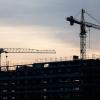 Kräne stehen hinter dem Rohbau für ein Bürogebäude auf einer Baustelle. Die Flaute am Bau hat sich auch im März fortgesetzt.