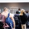 Fluggäste warten in der Abflughalle des Flughafens München vor einem Infoschalter der Lufthansa. Eine IT-Panne verursachte Verspätungen und Flugausfälle.