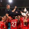 Münchens Trainer Hansi Flick wird von seinen Spielern in die Luft geworfen.