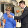 Ein großer Moment: Bundeskanzlerin Angela Merkel besucht im März 2015 den Augsburger Roboterbauer mit Vorstandschef Till Reuter.