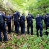 Beamte der Polizei suchen am Montag im Stuttgarter Schlossgarten mit Rundhölzern an dem Fundort zweier Leichen nach Spuren. Die Leichen einer Frau und eines Mannes in Koffern waren am Vorabend von Passanten in der Parkanlage gefunden worden.