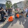 Polizisten versuchen Aktivisten der „Letzten Generation" vom Strassenbelag zu lösen.