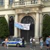 Klimaschützer klettern am Portal des Augsburger Rathauses empor und bringen ein Plakat an.                        
