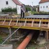 Die Roggdener Aufbachbrücke wurde abgerissen, weil sie marode war. E eine neue Brücke wird nun mitsamt neuer Kanalrohre und Wasserleitungen sowie neuer Stromleuchten errichtet. Bis zum Herbst soll alles fertig sein. Stadtbaumeister Fink deutet vor Ort auf das neue Fundament der Brücke.