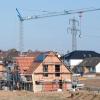 Einfamilienhäuser stehen im Rohbau in einem Neubaugebiet in der Region Hannover.