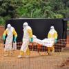 Helfer bringen ein Ebola-Opfer zu seiner Familie, wo es bestattet werden soll.