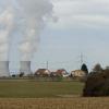 Nahe Harthausen ziehen die Masten und Leitungen der Hochspannungstrasse den Blick zu den Kondenswolken des Kernkraftwerks Gundremmingen mit Häusern der Gemeinde Rettenbach im Vordergrund. 