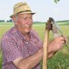 Sepp Hanrieder aus Mering schärft das Sensenblatt (links). Ganz vorsichtig kontrolliert er mit dem Daumen, ob das Blatt der Sense scharf genug ist (rechts).