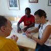 Ivan Kyambadde und DRW-Teamleiterin Nadine Bürle spielen gemeinsam mit einem Bewohner der Franziskuswohngruppe Uno. 