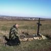 Kniend der Toten gedacht: Ein ukrainischer Priester kniet neben dem Grab eines gefallenen Soldaten.