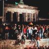 Jubelnde Menschen stehen am 09.11.1989 auf der Berliner Mauer vor dem Brandenburger Tor.