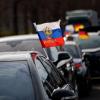 Russische Flaggen wehen an einem Auto vor dem Berliner Olympiastadion. Mit Blick auf pro-russische Demonstrationen fordern Innenpolitiker ein striktes Durchgreifen der Polizei bei Verstößen gegen Auflagen oder Gesetze.