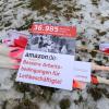 Ein Protestplakat für bessere Arbeitsbedingungen liegt vor dem Logistik-Center Amazon im hessischen Bad Hersfeld im Schnee.