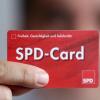 Ein SPD Mitglied zeigt sein Parteibuch im Checkkartenformat. Die SPD-Verbände bekommen nach dem Votum für Koalitionsgespräche mit der Union neuen Zulauf.