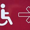 Ein Hinweis für Rollstuhlfahrer ist an einer Zufahrt angebracht.