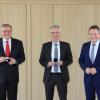 Hohe Auszeichnung für Vorstandsmitglied Karlheinz Wiesinger (links) und den Vorstandsvorsitzenden Thomas Schwarzbauer (Mitte): Landrat Leo Schrell übergab den beiden Bankern die Sparkassenmedaille in Gold.  