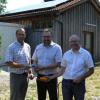 Tobias Stuhlenmiller (rechts) und Wolfgang Braun von der SoL Energie übergeben die neuen Photovoltaikanlagen auf den Königsmooser Abwasser-Pumpstationen an Bürgermeister Heinrich Seißler (links). 	