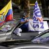 Eine Unterstützerin von Harris platziert vor einer Wahlkampfveranstaltung auf ihrem Fahrzeug eine Ecuadorianische und eine Flagge mit der Aufschrift der Kandidaten „Biden, Harris“.