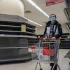 Mit Mundschutz unterwegs: Eine Frau geht in einem Supermarkt in Hongkong einkaufen. Viele Lebensmittelregale sind leer.