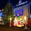 Besucher sehen sich beleuchtete Figuren und Lichter an einem privaten Weihnachtshaus an.