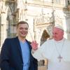 Kevin und Manuel posieren mit einer Figur von Papst Franziskus vor dem Regensburger Dom. 
