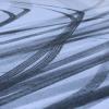 Reifenspuren zeichnen sich auf einer Straße im Schnee ab.