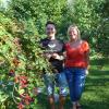 Gunther und Kathrin Seelos in ihrem Naturgarten an einem reich tragenden Brombeerstrauch.  