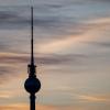 Die Wolken hinter dem Fernsehturms werden von der Sonne am frühen Morgen angestrahlt.