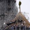 Arbeiter feiern den Abschluss des Wiederaufbaus des Dachstuhls der Kathedrale Notre Dame mit einem traditionellen Blumenstrauß.