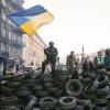 Ein Demonstrant schwenkt auf einer Barrikade in Kiew die Fahne der Ukraine.