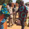 Eine Frau in Burkina Faso bedankt sich bei Pfarrer Emanuel für die gespendeten Lebensmittel.  	
